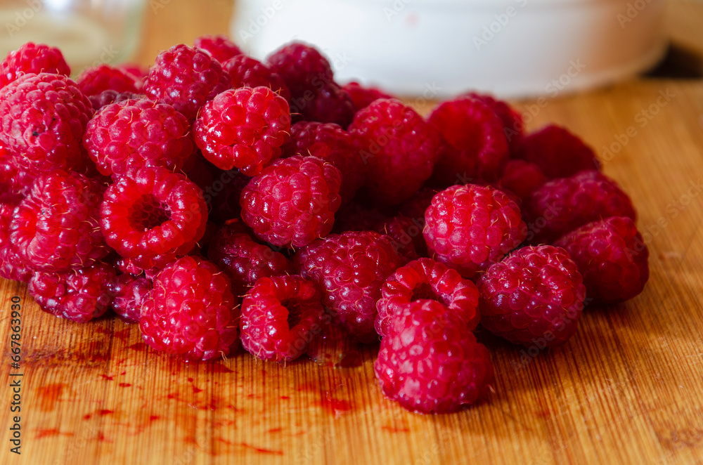 Red raspberries on a wooden board ready for making jam Red raspberries on a wooden board ready for making jam