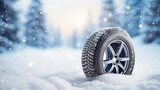 Car wheel with winter tires in a snowdrift on a snowy forest background. Free space for product placement or advertising text.