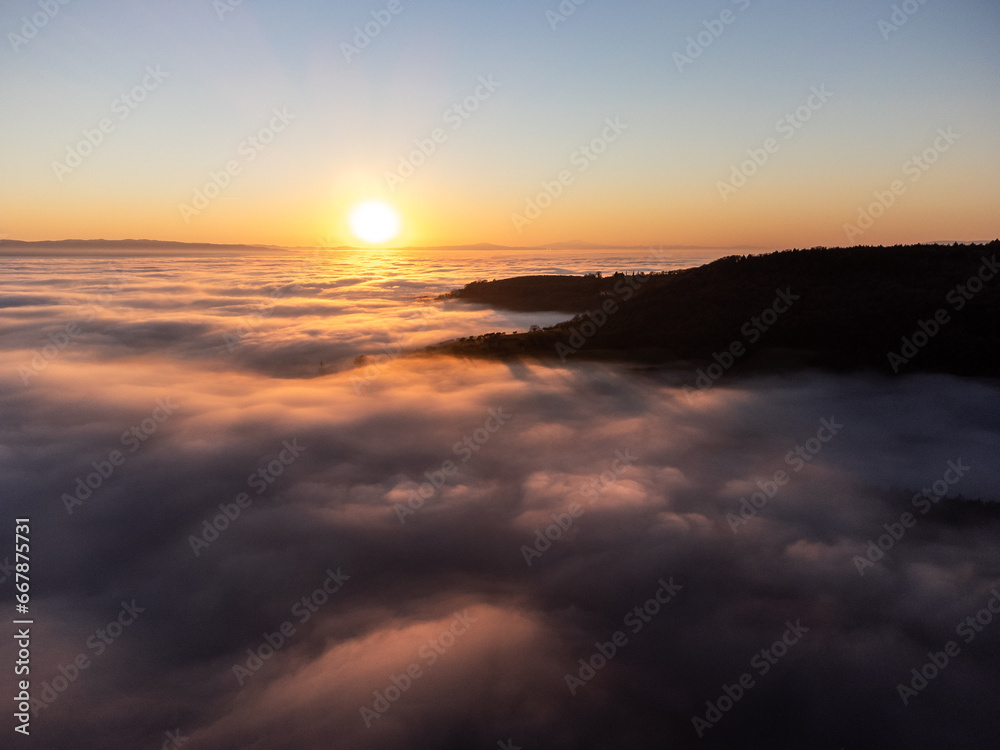 Drone view of Umbria valley Italy above a sea of fog at sunset
