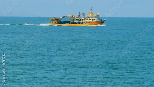 Seafood Production In The Sea Or Ocean. Fishing Boat Sails In The Open Sea. Real time. photo