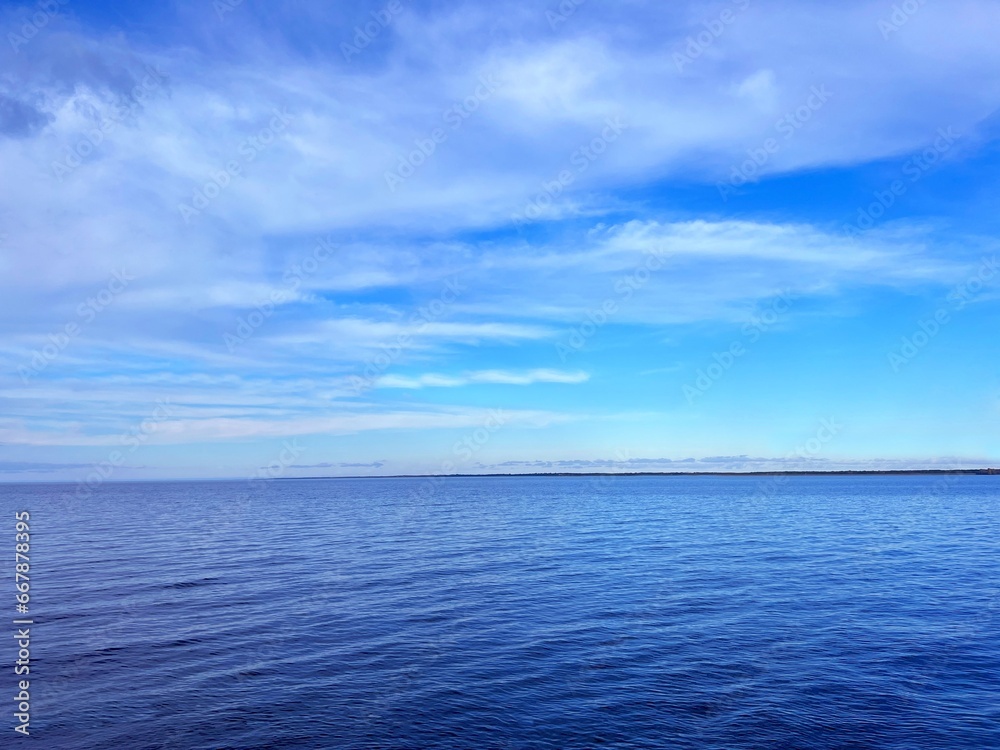 Blue sea water, sky, clouds, horizon.