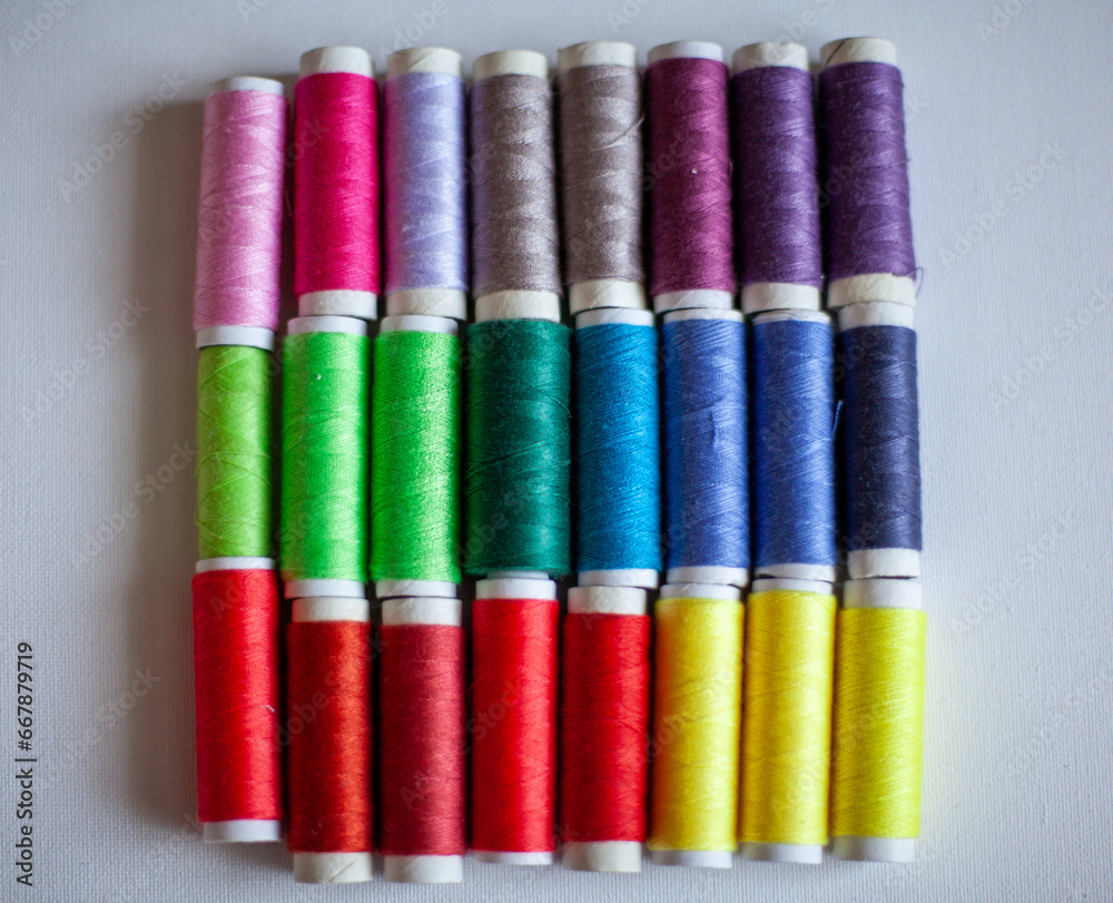A set of colourful spools of thread placed in three rows A set of colourful spools of thread placed in three rows