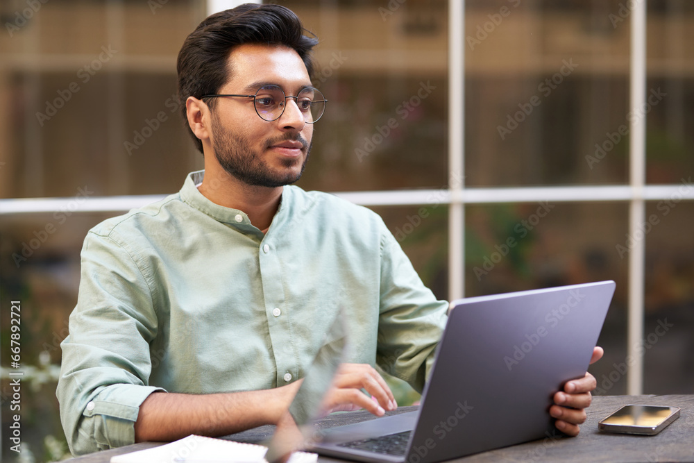 Stylish businessman sitting in modern coworking and working on laptop. High quality photo Stylish businessman sitting in modern coworking and working on laptop. High quality photo