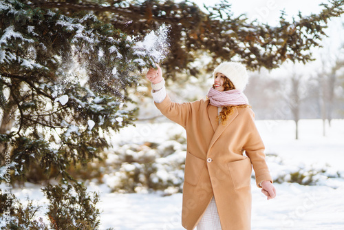 Beautiful portraits of a woman in a winter forest. She enjoys the first snow during the New Year holidays. Walk in winter forest.