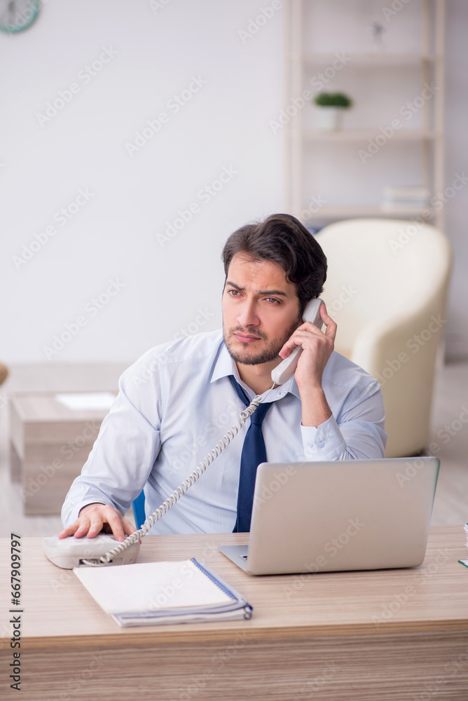 Young male employee working in the office Young male employee working in the office