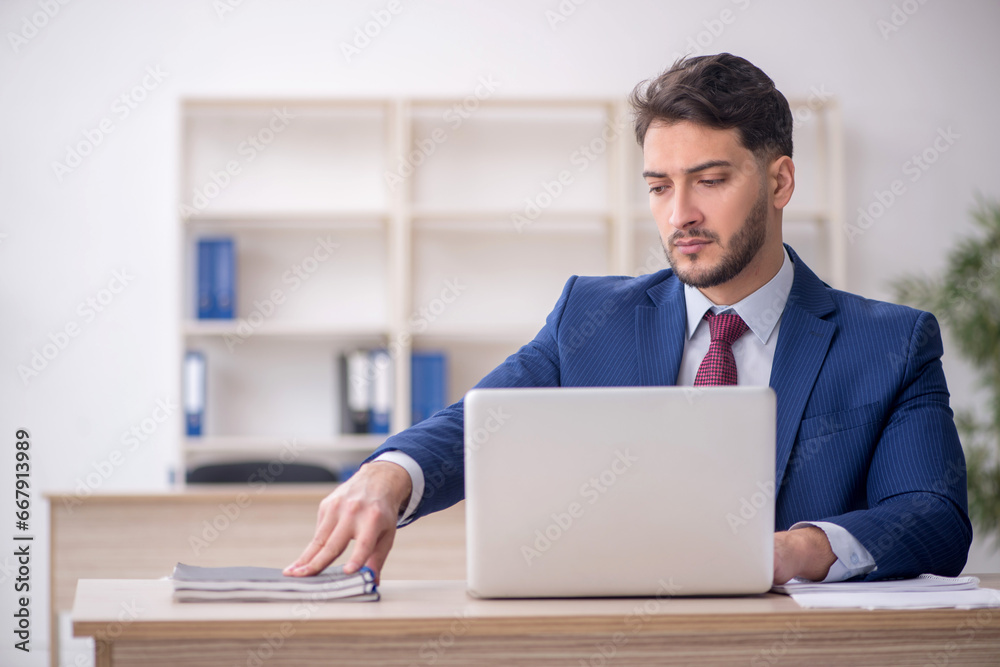 Young male employee working in the office Young male employee working in the office