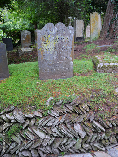 Alte Grabsteine unter Baumfarnen im malerischen Friedhof von St. Just in Roseland Church Cornwall England photo