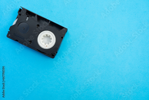 An Old VHS-C Compact Cassette on a Blue Background with Text Space