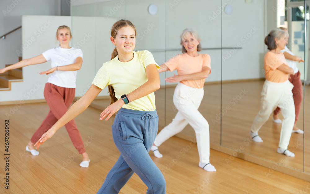 Girl dancing with her relatives during group aerobic training.
