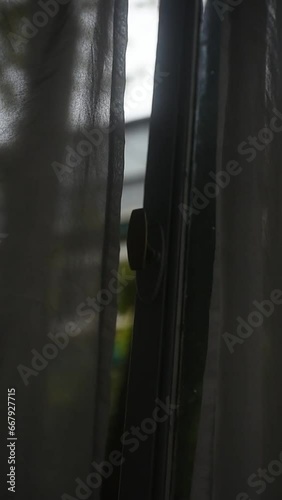 close up of window curtains moving because of the wing, rain in the window