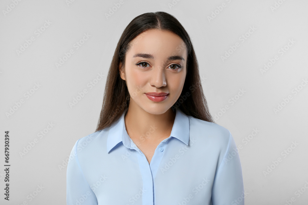 Portrait of beautiful young woman on light grey background Portrait of beautiful young woman on light grey background