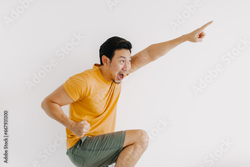 Happy exciting face of asian man jumping isolated on white.