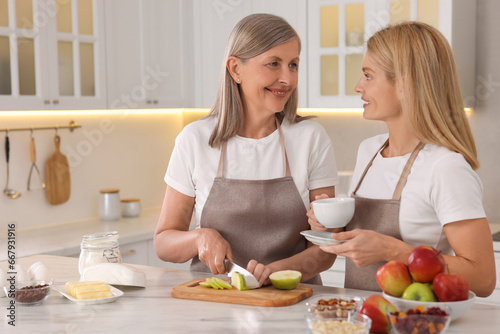 Happy mature mother with her daughter at kitchen