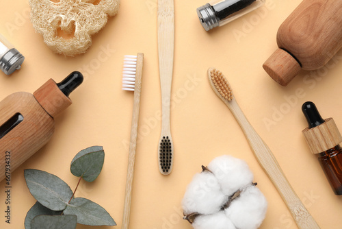 Flat lay composition with bamboo toothbrushes on pale orange background