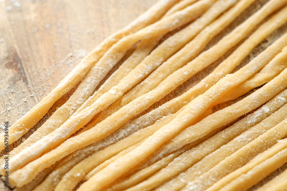 Raw homemade pasta and flour on wooden table, closeup Raw homemade pasta and flour on wooden table, closeup