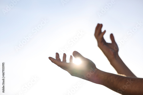Feeling freedom. Man reaching for sky on sunny day, closeup of hands