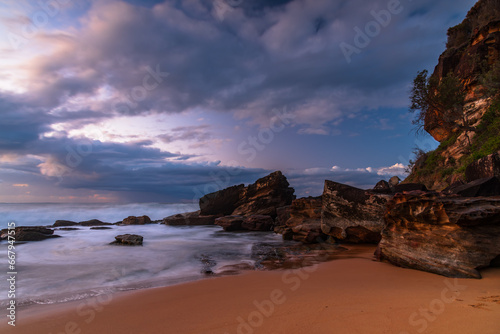 Sunrise seascape with low clouds and waves