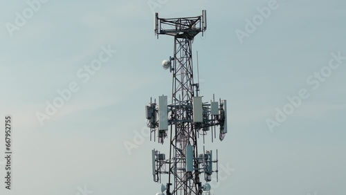Television or radio telephone tower in a cityscape at day time. Zoom aerial drone shot