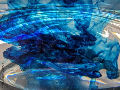 Blue dye dissolving in acid background
