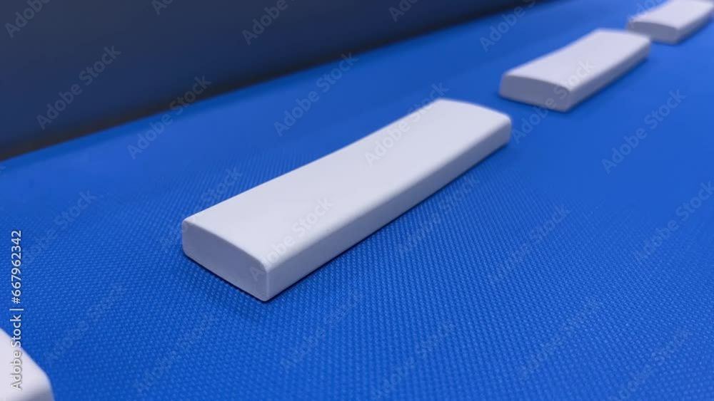 Industrial Conveyor Belt Demonstration with White Blocks in Motion Industrial Conveyor Belt Demonstration with White Blocks in Motion