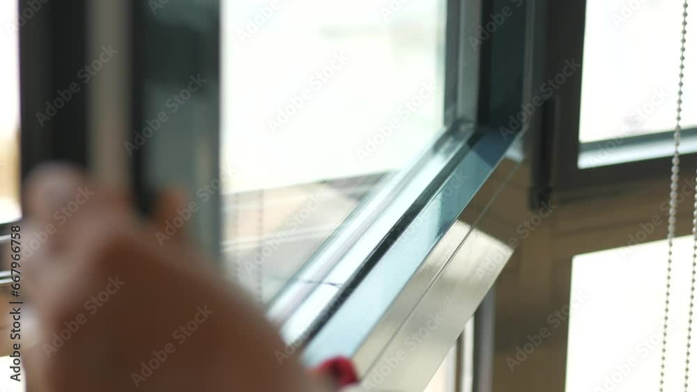 hand cleaning window glass with towel 