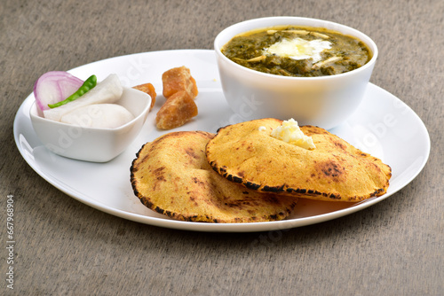 Traditional punjabi food sarson ka saag with makki ki roti served with jaggery and salad photo