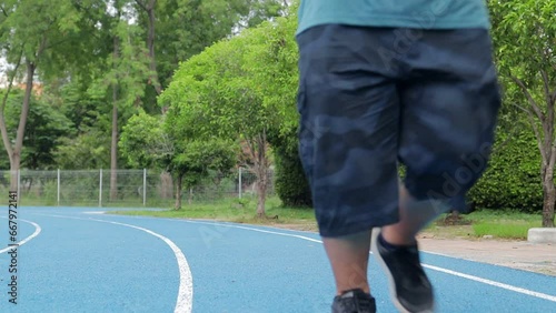 Fat Asian man jogging in a sports stadium. Sports concept. Losing weight and maintaining a healthy body