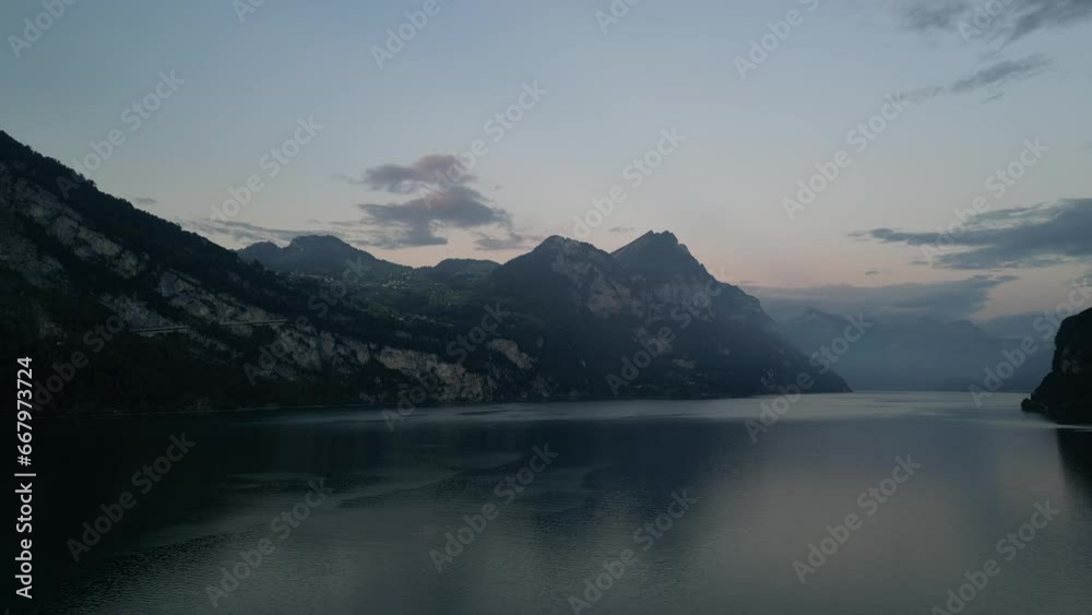 An astounding view of the serene waters of Lake Walensee, surrounded by majestic mountains An astounding view of the serene waters of Lake Walensee, surrounded by majestic mountains