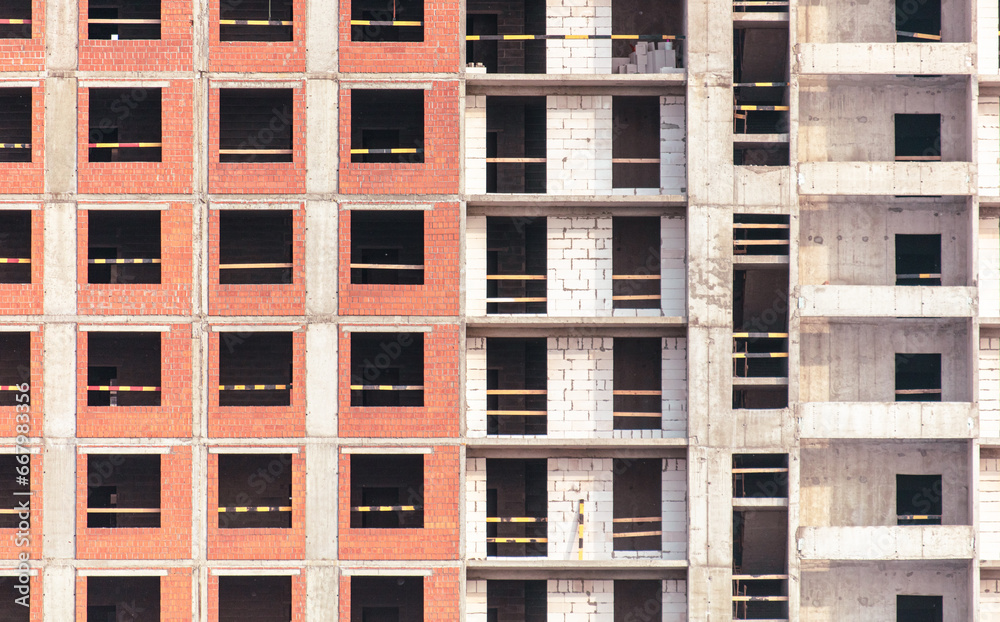 The walls of a multi-story building under construction as a background. Texture The walls of a multi-story building under construction as a background. Texture