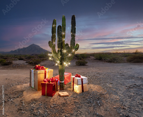 A festive Christmas cactus with illuminated decorations and gifts in a desert landscape at sunset photo