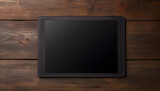 Black tablet on dark wooden surface.