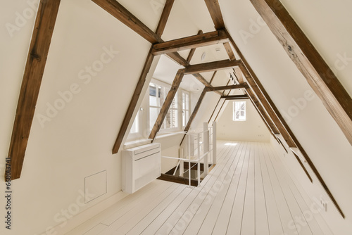 an attic room with white walls and wooden beams on the ceiling there is a small desk in front of the window