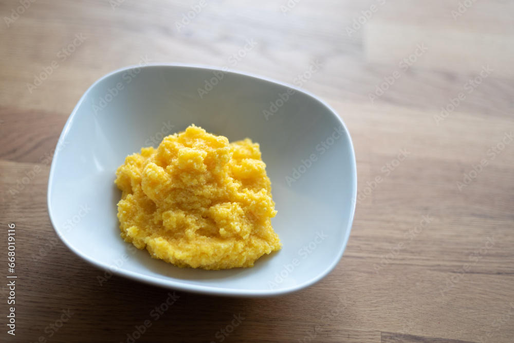 Bowl with polenta. Traditional Italian dish of boiled cornmeal. Shallow depth of field. Bowl with polenta. Traditional Italian dish of boiled cornmeal. Shallow depth of field.