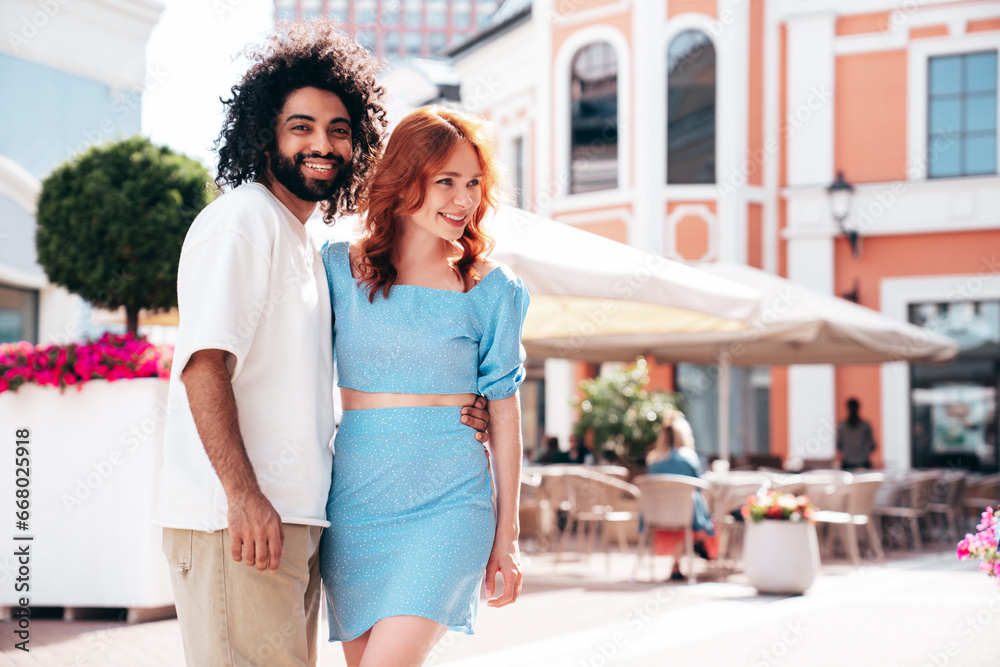 Smiling beautiful redhead  woman and her handsome boyfriend. Model in casual summer clothes. Happy cheerful family. Female having fun. Couple posing in the street at sunny day. Cheerful and happy