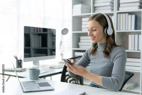 Woman wearing headphones and using a phone enjoying listening to music.