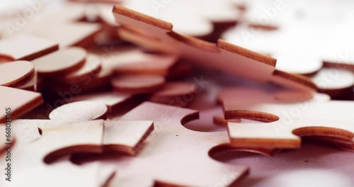 A closeup of Jigsaw Puzzle pieces placed on a turning table revealing pieces exposed to light and creating shadows. photo