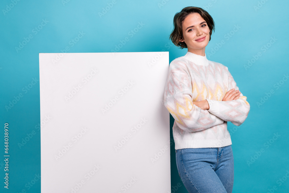 Portrait of gorgeous positive girl folded arms showing empty space proposition ad isolated on blue color background Portrait of gorgeous positive girl folded arms showing empty space proposition ad isolated on blue color background