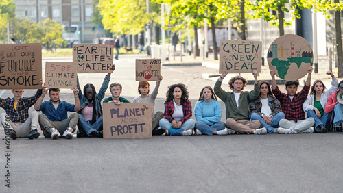 Environmental activists protesting for change - A group of activists gather in an urban setting, holding signs that call for action against climate change. Their placards bear powerful messages. © Lomb