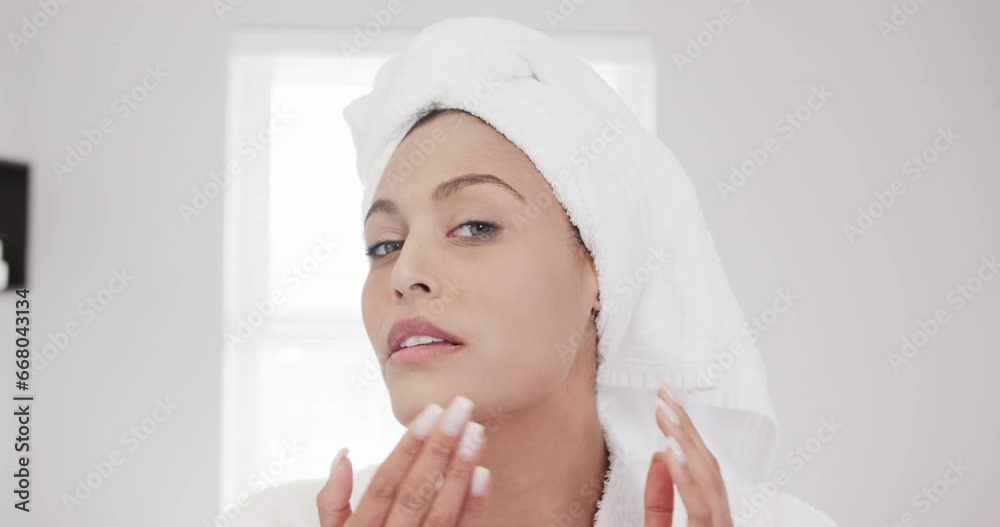 Portrait of happy biracial woman massaging face in bathroom, slow motion Portrait of happy biracial woman massaging face in bathroom, slow motion