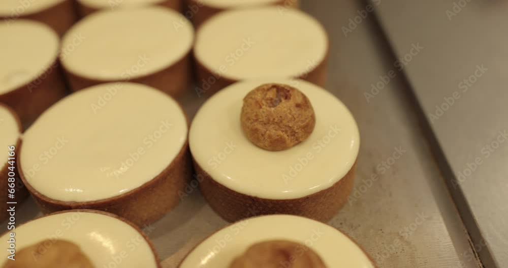 Pastry hands decorate the tops of mini tartlets. The baking process is slow. Pastry hands decorate the tops of mini tartlets. The baking process is slow.