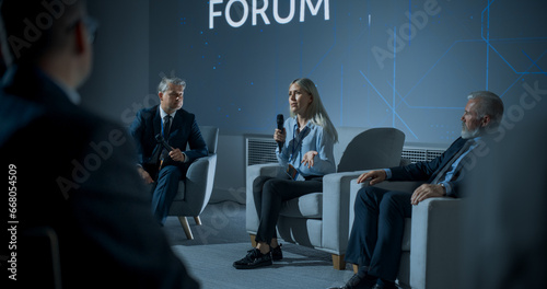 Obraz na płótnie International Technology Conference: Male Host Asking Caucasian Female CEO a Question In Front Of Audience