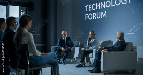 International Technology Conference: Male Host Asking Caucasian Female CEO a Question In Front Of Audience. Successful Woman Delivering Inspirational Speech And Diverse Attendees Listening Carefully.