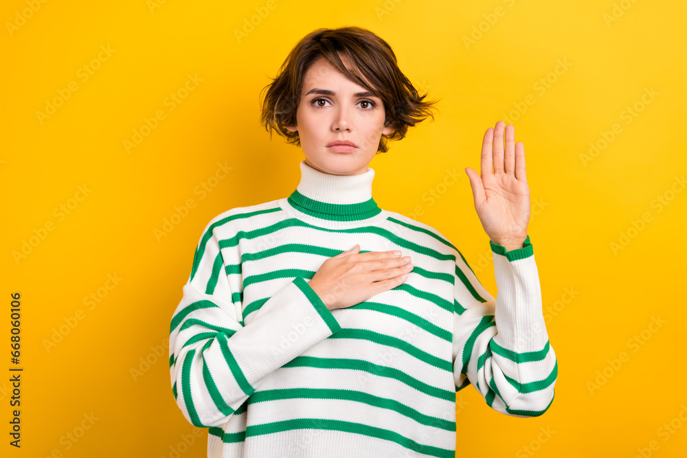 Photo of shiny serious lady wear striped pullover rising arm palm swearing tell truth isolated yellow color background Photo of shiny serious lady wear striped pullover rising arm palm swearing tell truth isolated yellow color background