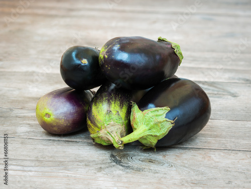 Fresh eggplants on an unpainted wooden rustic table photo