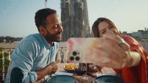 Young multiethnic couple dating for a romantic dinner on a beautiful terrace penthouse in Barcelona