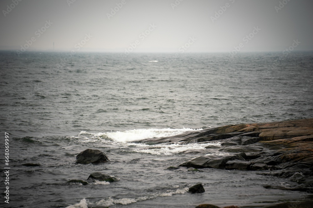 a view of the ocean from a rocky shore at dusk