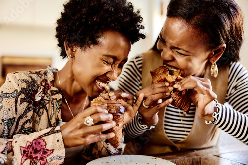 Laughing women eating croissants photo
