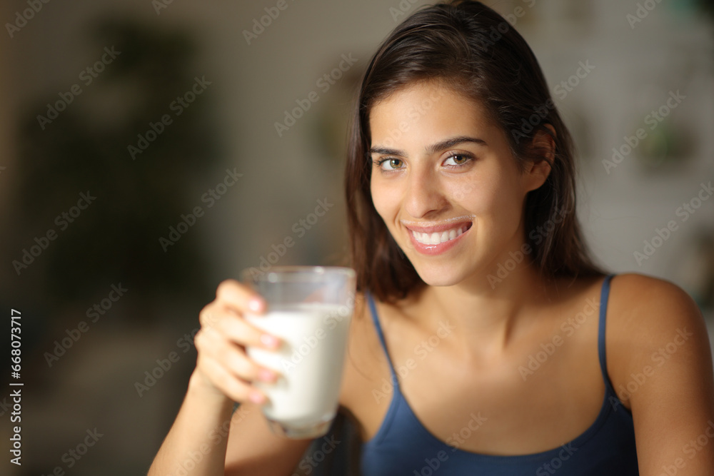 Happy woman posing holding milk glass in the night Happy woman posing holding milk glass in the night