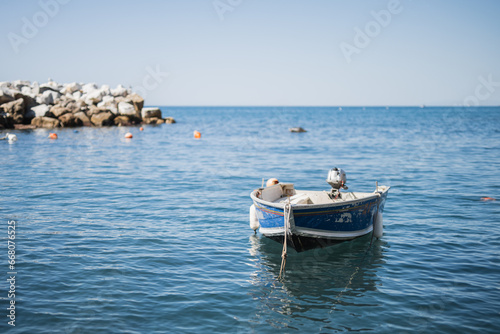 Fishing wooden boat in the sea off the coast of a cozy village in the Mediterranean Sea