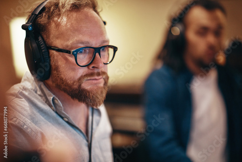 Music producer listening to tracks in a recording studio photo